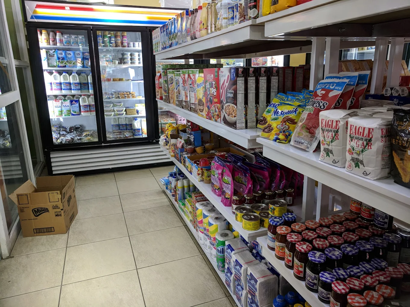 Grocery shelves with dairy cooler, cereal and pantry items